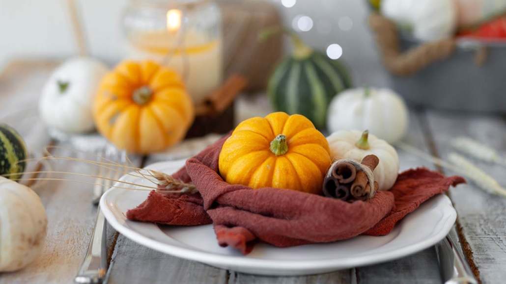 Photo of pumpkins and candle on a wooden table