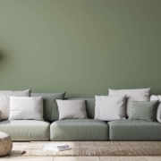 Image of Scandinavian home decor with green couch, rattan pot and floor lamp