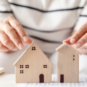 woman is deciding to choose house with Small Wooden House Model