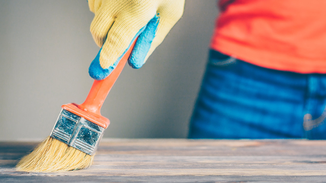 Waxing and oiling with a brush on a wooden table