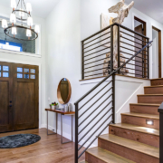 Chic entrance foyer with high ceiling and wide staircase with lights and contemporary railing