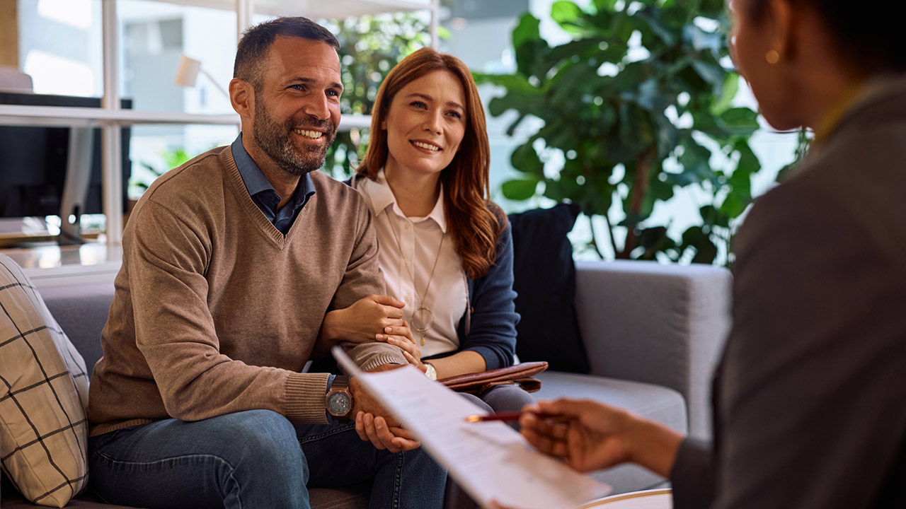 Happy couple having consultations with real estate agent in the office