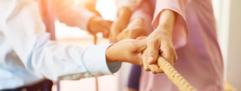 Team of coworker pulling rope together stock photo