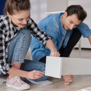 couple installing bookshelf for new house stock photo