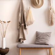 Cosy entryway with grey bench, coffee table, hanger and personal accessories stock photo