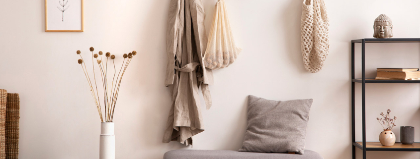 Cosy entryway with grey bench, coffee table, hanger and personal accessories stock photo