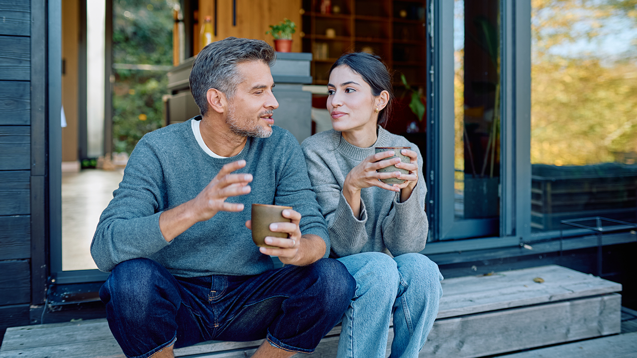 Couple relaxing and enjoying coffee while talking outdoors stock photo
